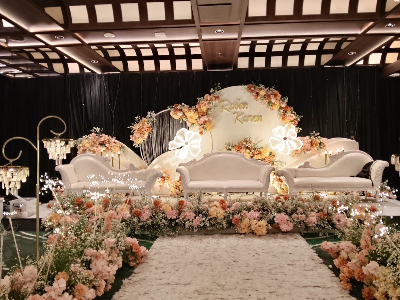 Amber and blush floral aisle with illuminated white flower motifs
