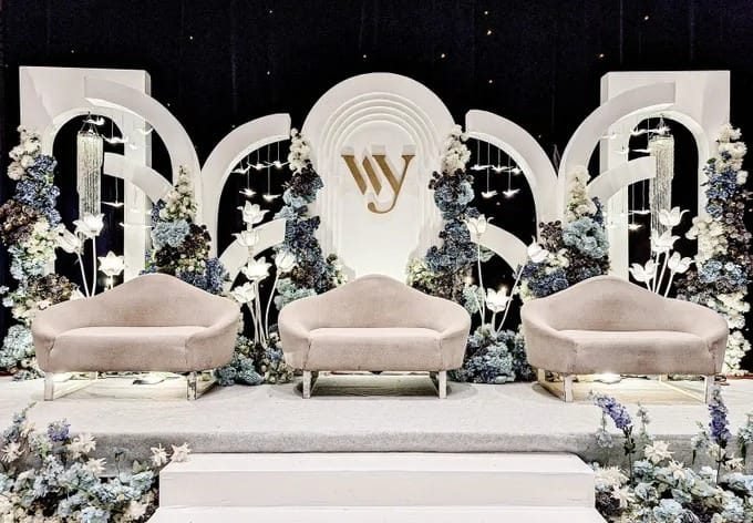 Arched cream stage backdrop with dusty blue floral clusters