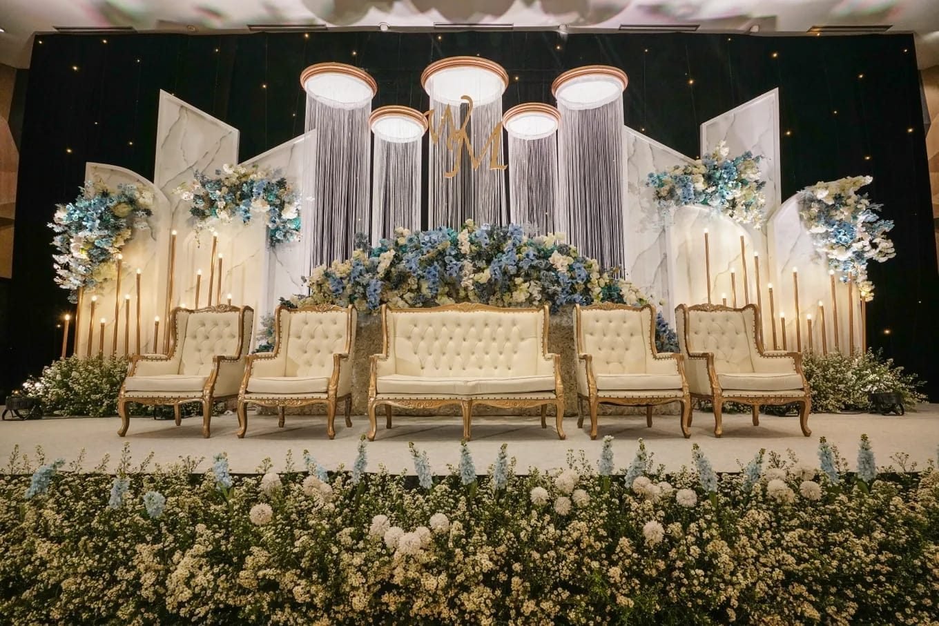 Marble panel backdrop with dusty blue florals and gold candlesticks