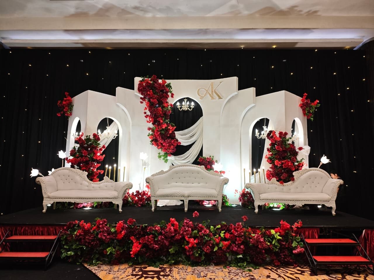Classic white arched backdrop with cascading deep red roses